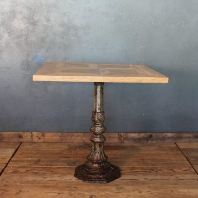 Tavolo composto con una base in ghisa lavorata e piano in legno di recupero